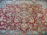 an image of a red and blue rug with a floral design on it