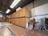 many wooden boxes stacked up in a large warehouse