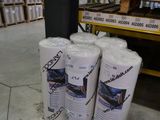 three rolls of toilet paper sitting on the floor in a warehouse