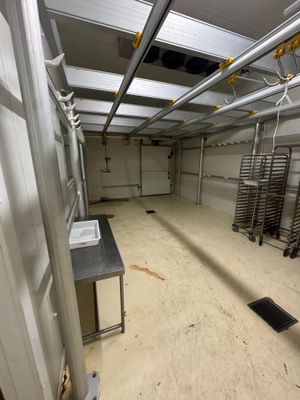 une grande pièce avec de nombreux rayonnages métalliques et des tables