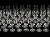 a lot of wine glasses that are lined up together