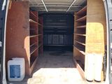 the back of a van with the door open and shelves in the back of it