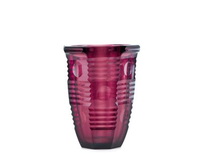 un verre en verre violet posé sur une table
