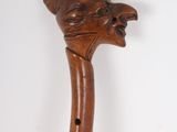 an old wooden walking stick with a cat head carved into it
