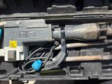 une perceuse et d'autres outils rangés dans une mallette posée par terre