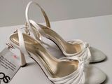 white wedding shoes with a tag on the side of them