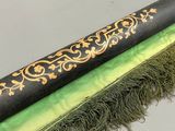 une image représentant un pinceau noir et vert orné d'une bordure dorée