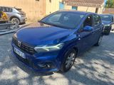 une voiture bleue garée dans un parking à côté d'un bâtiment