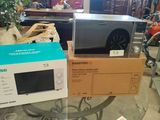deux micro-ondes posés sur des cartons, sur une table