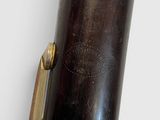 an old brass plated clarinet with a black case and brass fittings