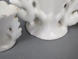 two white vases sitting next to each other on a table