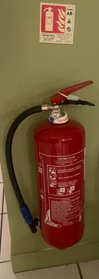 un extincteur à côté des toilettes dans une salle de bains
