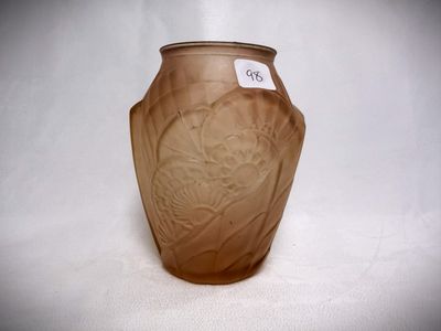 a brown vase with a label on it on a white surface