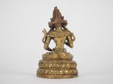 a gold statue of a person sitting on top of a table