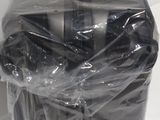a black suitcase wrapped in plastic on a white surface