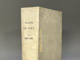 un vieux livre posé sur une table à côté d'un mur gris