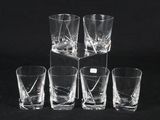 six shot glasses sitting on top of a black table next to each other