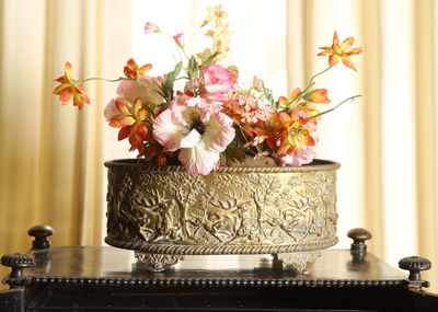 a vase with flowers in it on top of a piano