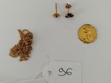 three pairs of earrings and a gold coin on a white surface