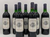 six bouteilles de vin sont alignées sur une surface blanche
