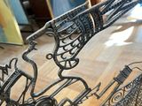a metal sculpture of a horse and carriage on a wooden floor
