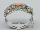 a close up of a silver ring with orange stones on it