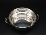 a silver bowl on a black table with a black background