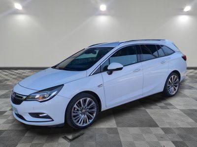 une Opel blanche garée dans une pièce au sol en damier