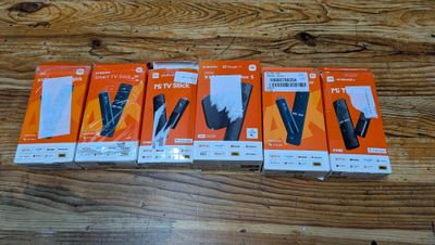 four boxes of nintendo wii remotes sitting on a wooden table