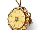 une photo d'un pendentif en forme de boussole en or, orné d'un diamant au centre
