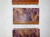 three pieces of wood with purple and yellow paint on them