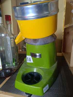 a green and yellow juicer sitting on a counter
