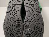 the soles of a pair of green shoes on a white surface