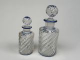 two glass bottles that are sitting next to each other
