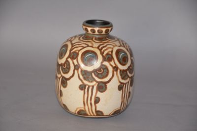 un vase brun et blanc posé sur une table