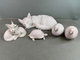 une figurine blanche représentant un chat, une tortue et une balle