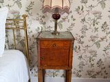 un lit sur lequel se trouvent une couette blanche et une lampe