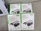 four boxes of belkin power charger sitting on a couch