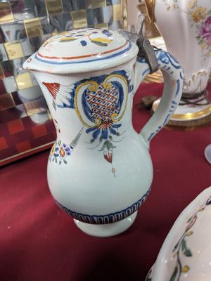 a white vase with a blue and yellow design on it
