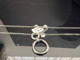 a silver necklace with a silver ring on a chain