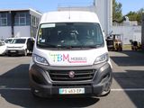 une camionnette blanche garée sur un parking à côté d'un bâtiment