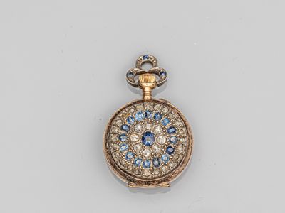 un gros plan d'une montre de poche ornée de pierres bleues et blanches