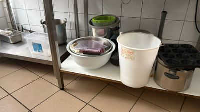 two buckets and a bucket on a shelf in a kitchen
