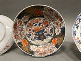 two plates and a bowl are sitting side by side on a table