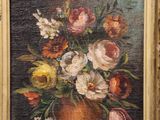 painting of a vase of flowers in a gold frame on a black background