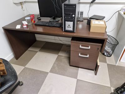 a desk with a computer on top of it in a room