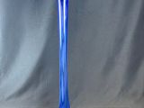 un vase en verre bleu posé sur une surface grise