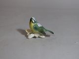a small figurine of a bird sitting on a flower