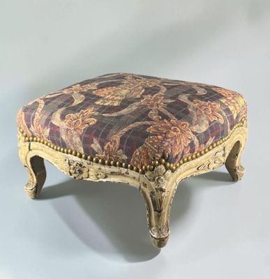 a foot stool with a floral upholstered seat