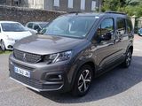 La camionnette grise est garée sur le bord de la route, sur le parking.